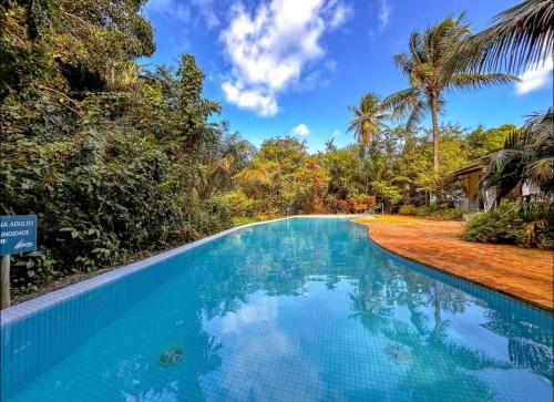 a swimming pool in a resort with trees at Casa na Reserva Sapiranga, Praia do Forte in Mata de Sao Joao