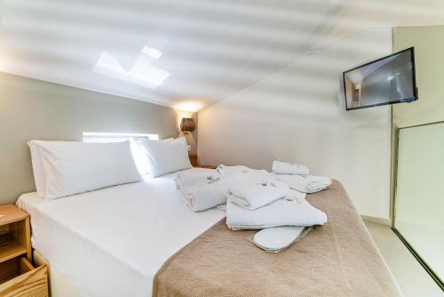 a bedroom with a white bed with towels on it at Pelagus Luxury Villas in Polykhrono