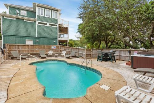 a pool on a patio with chairs and a table at 2135 - Pirates Perch in Duck