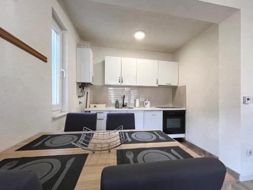 a kitchen with white cabinets and a table and chairs at Heaven Premium apartments in Sarajevo