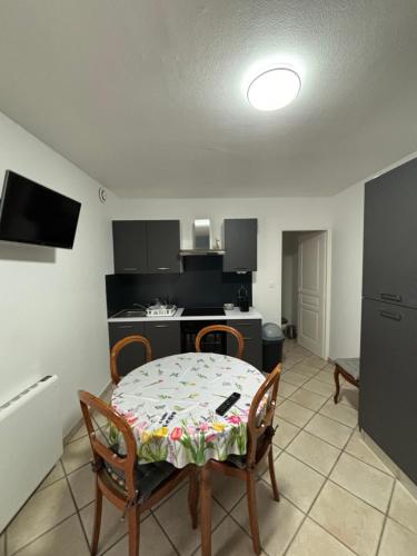 une salle à manger avec une table et des chaises et une cuisine dans l'établissement Bonheur, à Colombier-Saugnieu