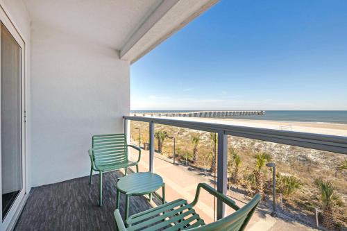 a balcony with chairs and a view of the beach at Best Western Oceanfront in Jacksonville Beach