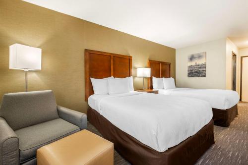 a hotel room with two beds and a chair at Best Western Chicago - Downers Grove in Downers Grove
