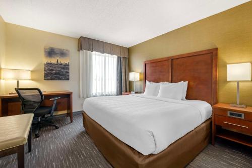 a hotel room with a large bed and a desk at Best Western Chicago - Downers Grove in Downers Grove