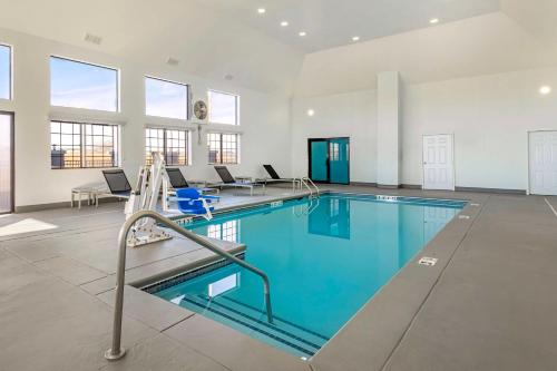 a large swimming pool with blue water in a building at Best Western Park City Wichita North in Park City
