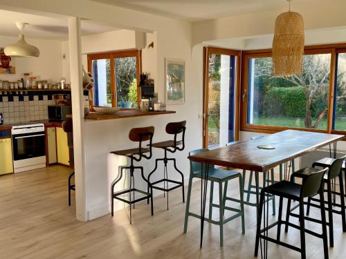 une cuisine et une salle à manger avec une table et des chaises en bois dans l'établissement La Zaï Zaï, maison du Cabellou face à la mer, à Concarneau