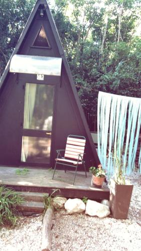 a tent with a bench and a chair on a porch at Forest Glam in San Andrés de Giles