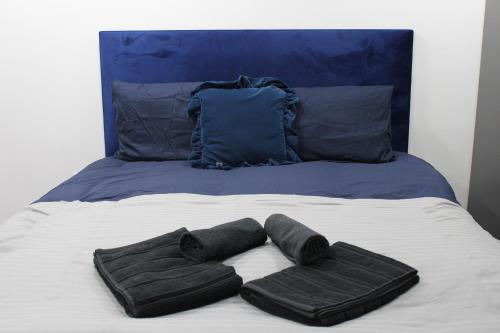a bed with two towels and two pillows on it at Bevois Valley Serviced Apartments - Comfort and Convenience in Southampton