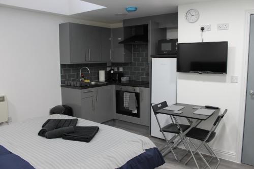 a kitchen with a bed and a table in a room at Bevois Valley Serviced Apartments - Comfort and Convenience in Southampton