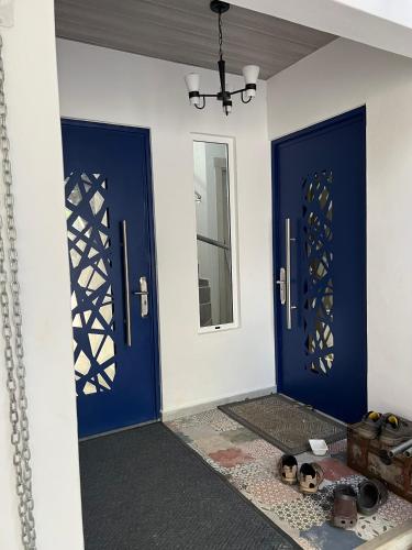 a room with two blue doors and a mirror at Rainbow Iris in Los Naranjos