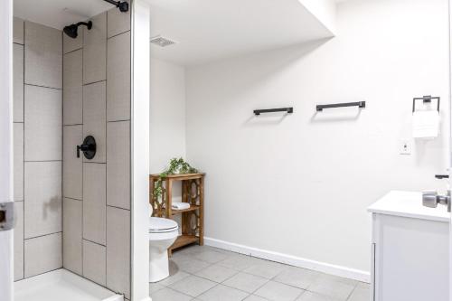 a white bathroom with a toilet and a shower at Renovated House for 14 in Wentzville MO in Wentzville