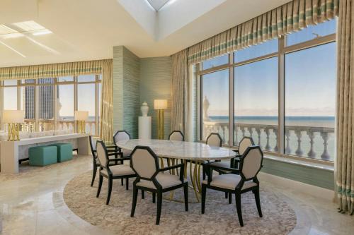 a dining room with a table and chairs and windows at Sheraton Batumi Hotel in Batumi