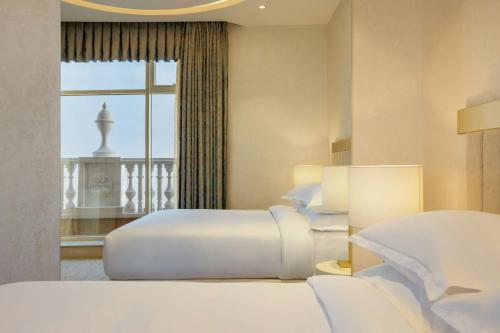 a hotel room with two beds and a window at Sheraton Batumi Hotel in Batumi