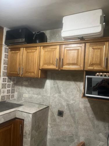 a kitchen with wooden cabinets and a counter top at Pinky s Place Alajuela City Airport Costa Rica in Alajuela City
