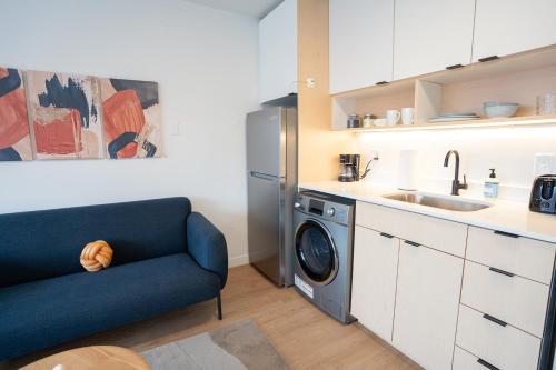 a kitchen with a washing machine and a blue couch at Salt City Penthouse in Salt Lake City