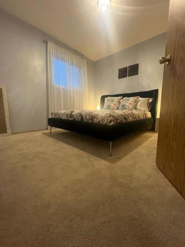 a bedroom with a bed in a room with a window at Home away from home!! in Calgary