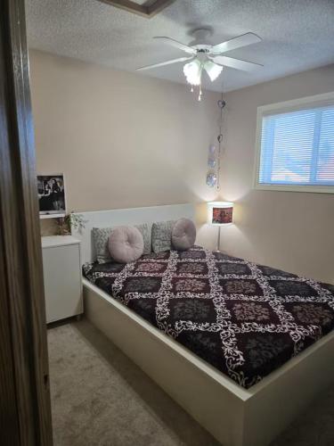 a bedroom with a bed with a ceiling fan at Home away from home!! in Calgary