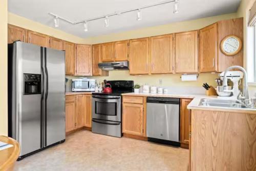 a kitchen with wooden cabinets and a stainless steel refrigerator at Home away from home!! in Calgary