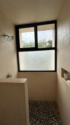 a bathroom with a window and a bath tub at IK Casa del viento in Chetumal