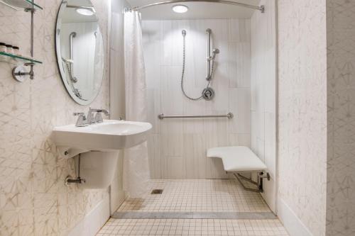 a white bathroom with a sink and a shower at Sheraton Suites Philadelphia Airport in Philadelphia