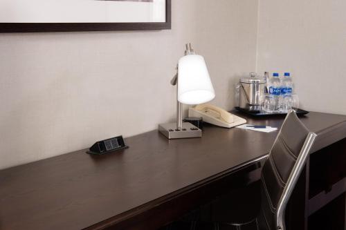 a desk with a lamp and a phone on it at Sheraton Suites Philadelphia Airport in Philadelphia