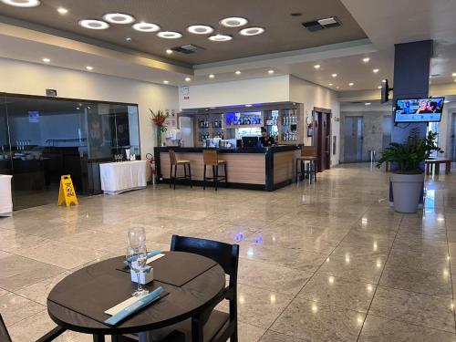 a restaurant with a table and chairs and a bar at Frente Mar - Beach Class Internacional - Flat Boa Viagem in Recife