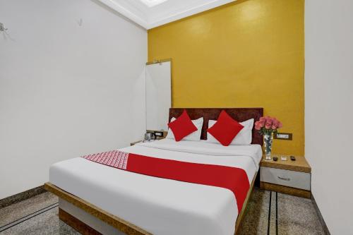 a bedroom with a large bed with red pillows at Hotel O Chhaya in Aurangabad