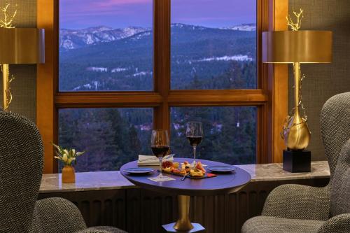 a table with two glasses of wine in front of a window at The Ritz-Carlton, Lake Tahoe in Truckee