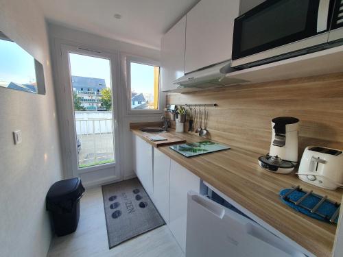 une cuisine avec un comptoir et une fenêtre dans l'établissement LA BAULOISE, à La Baule