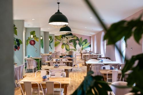 a dining room with tables and chairs and plants at The Forest at Mount Congreve Gardens in Kilmeaden