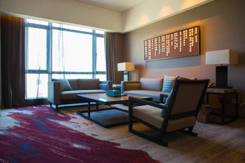 a living room with two couches and a coffee table at Wyndham JinJiang Hotel in Jinjiang