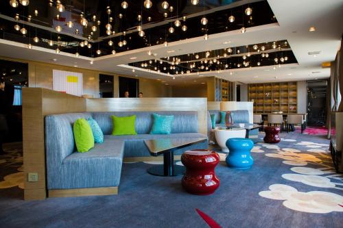 a lobby with a blue couch with green pillows at Wyndham JinJiang Hotel in Jinjiang