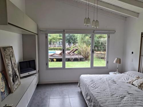 a bedroom with a bed and a large window at Casa linda con pileta y parque in San Pedro