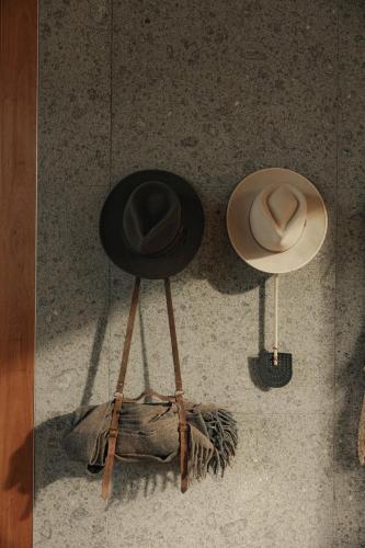two hats sitting on a tripod on the floor at Upland Farm Luxury Cabins, Denmark Western Australia in Denmark