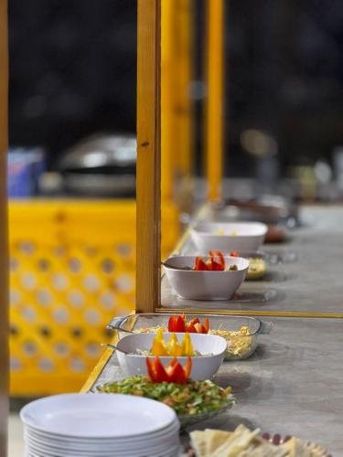 a buffet line with plates and bowls of food at WADI RUM AJWAN lUXURY CAMP in Wadi Rum