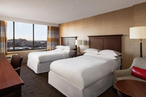 a hotel room with two beds and a chair at Sheraton Philadelphia University City Hotel in Philadelphia