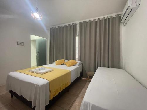 a hotel room with two beds and a mirror at Pousada Paraíso das Águas Capitólio in Capitólio