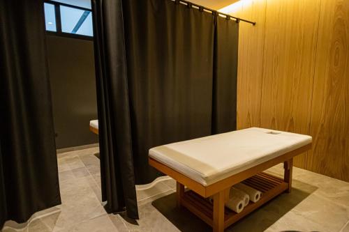 a room with a bench and a shower with a bench sidx sidx sidx at Andon Lapa Hotel & Spa in Sarandë