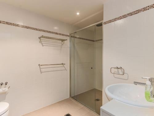 Un baño con ducha de cristal y lavabo. en Cabarita Mountain View, en Cabarita Beach