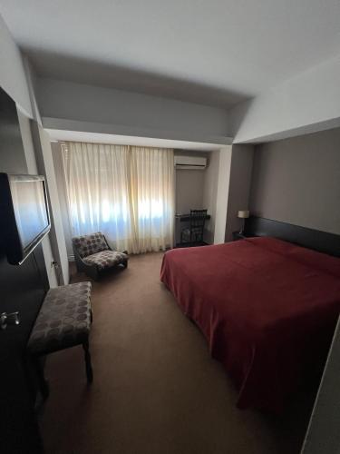 サン・フランシスコにあるAires del libertadorのベッドルーム(赤いベッド1台、椅子付)