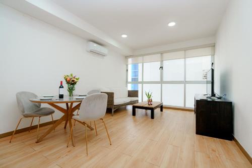 Una sala de estar blanca con una mesa y sillas. en Boutique Apartments Panamá Marbella, en Panamá