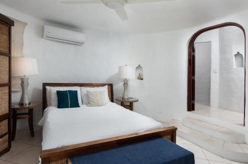 a white bedroom with a bed and a mirror at Coralita Apartments in Saint Michael