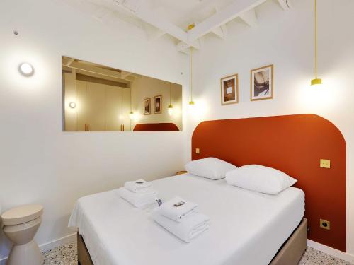 - une chambre avec un lit doté de draps blancs et d'une tête de lit rouge dans l'établissement Cosy apartment 2P close to Sacré-Coeur, à Paris