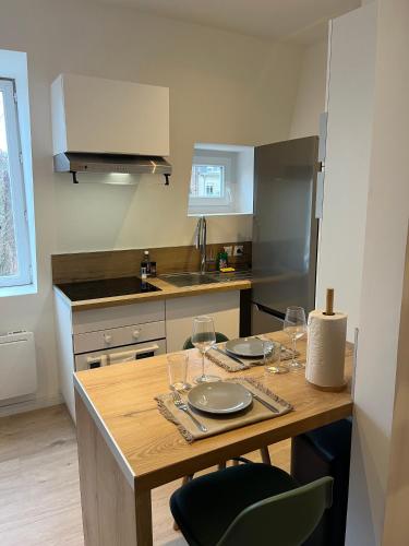 - une cuisine avec une table en bois et des verres à vin dans l'établissement Au fil de l'eau, Gare, Wifi, TV, Parking, à Douai