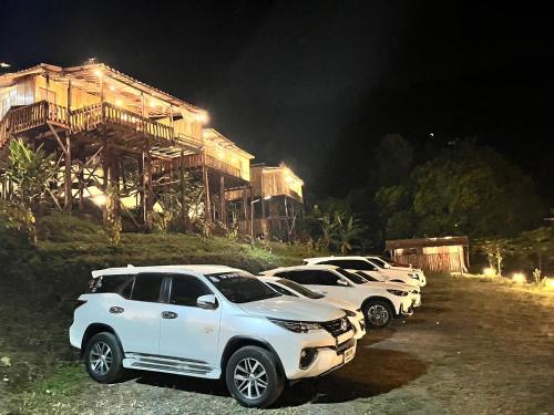 a row of white cars parked in front of a building at บ้านลิ้นจี่โฮมสเตย์ Baan Lychee homestay in Ban Thung Phan Ha