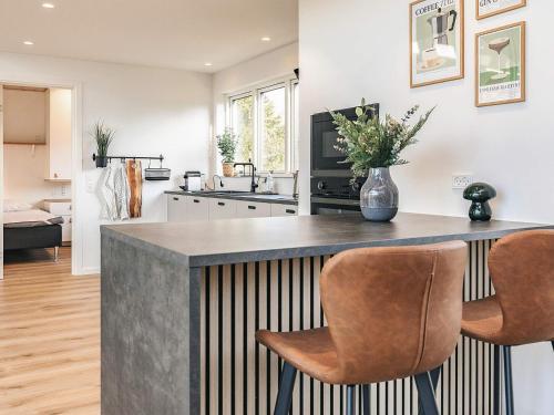 a kitchen with a counter and two chairs at 8 person holiday home in Væggerløse-By Traum in Marielyst