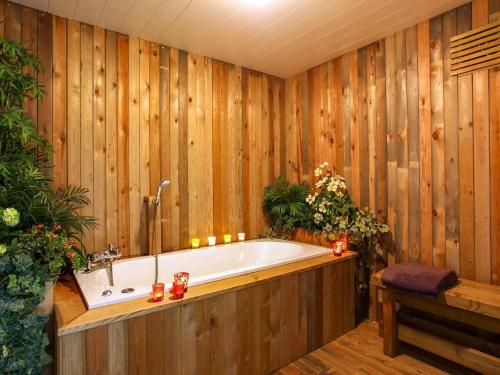 a bath tub in a room with wooden walls at Escape at Mont Saint Jacques in Trois-Ponts