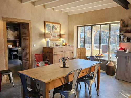 une salle à manger avec une table et des chaises en bois dans l'établissement Charmante maison avec jardin au cœur du Parc Naturel Régional de la Brenne, idéale pour télétravail. - FR-1-591-237, à Rosnay