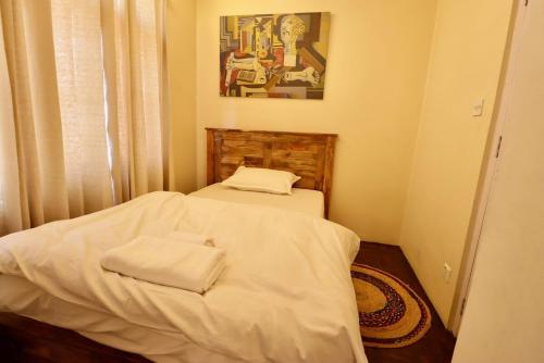 a small bedroom with two beds with white sheets at Wanderer's Home Dhumbarahi in Kathmandu