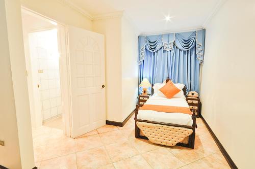 a bedroom with a bed and a blue curtain at Paradise Garden Hotel and Convention Center Boracay Powered by ASTON in Boracay